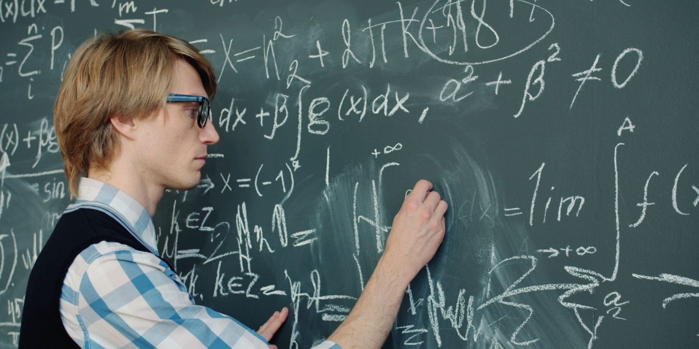 Matematyk zapisujący skomplikowane równania na tablicy