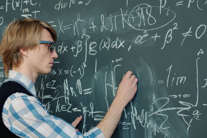 Matematyk zapisujący skomplikowane równania na tablicy