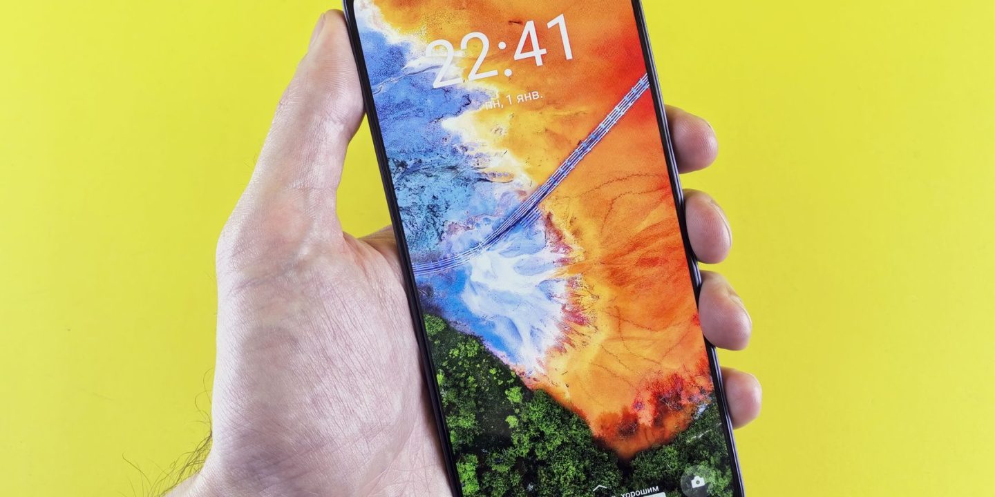 Nowoczesny smartfon z jasnym ekranem OLED trzymany w dłoni