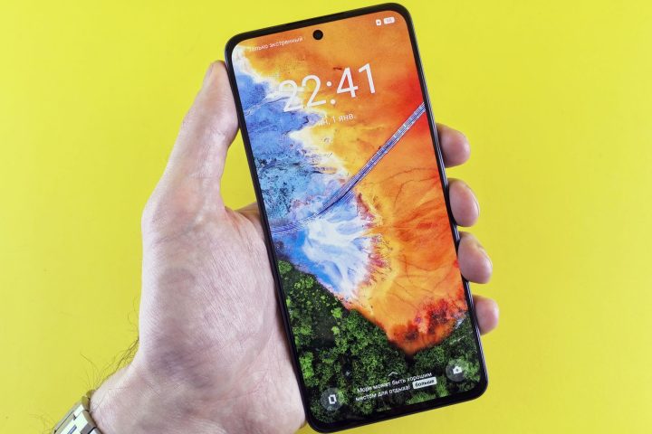 Nowoczesny smartfon z jasnym ekranem OLED trzymany w dłoni