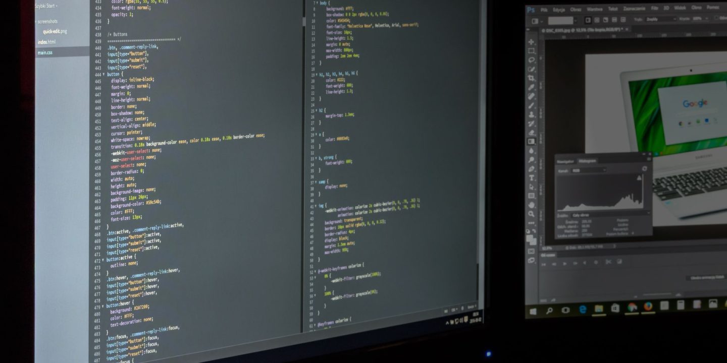 Programista pracujący przy dwóch monitorach z otwartym kodem źródłowym