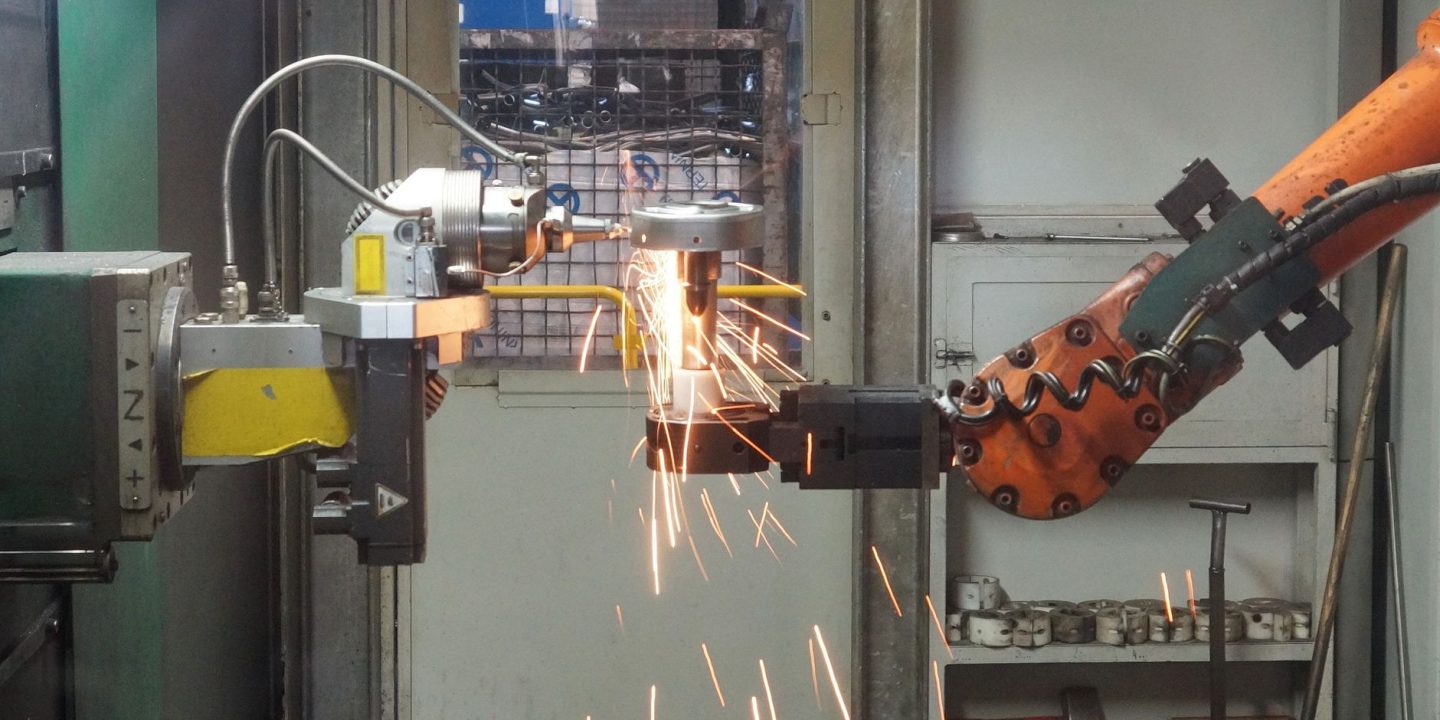 Ramiona robotów przemysłowych pracujące przy linii produkcyjnej w fabryce
