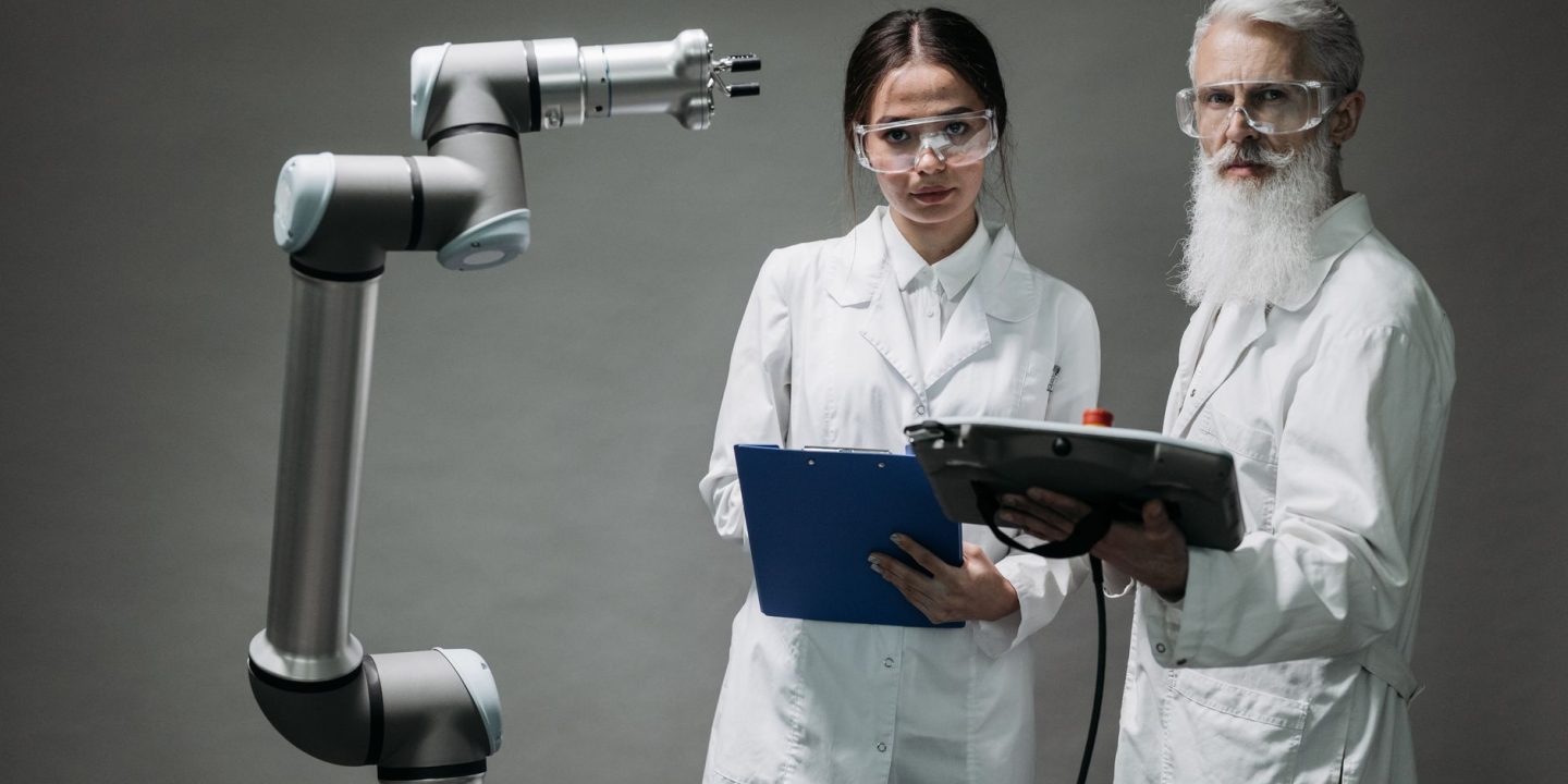 Inżynier robotyki analizujący dokumentację patentową przy robocie przemysłowym