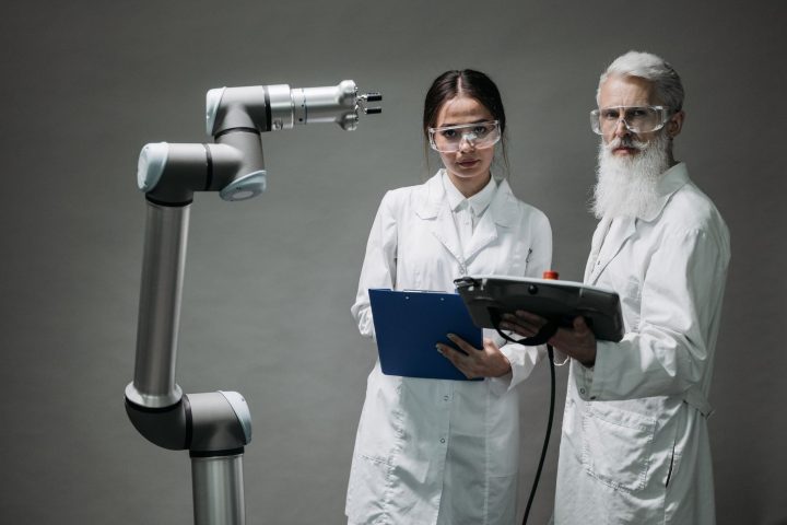Inżynier robotyki analizujący dokumentację patentową przy robocie przemysłowym