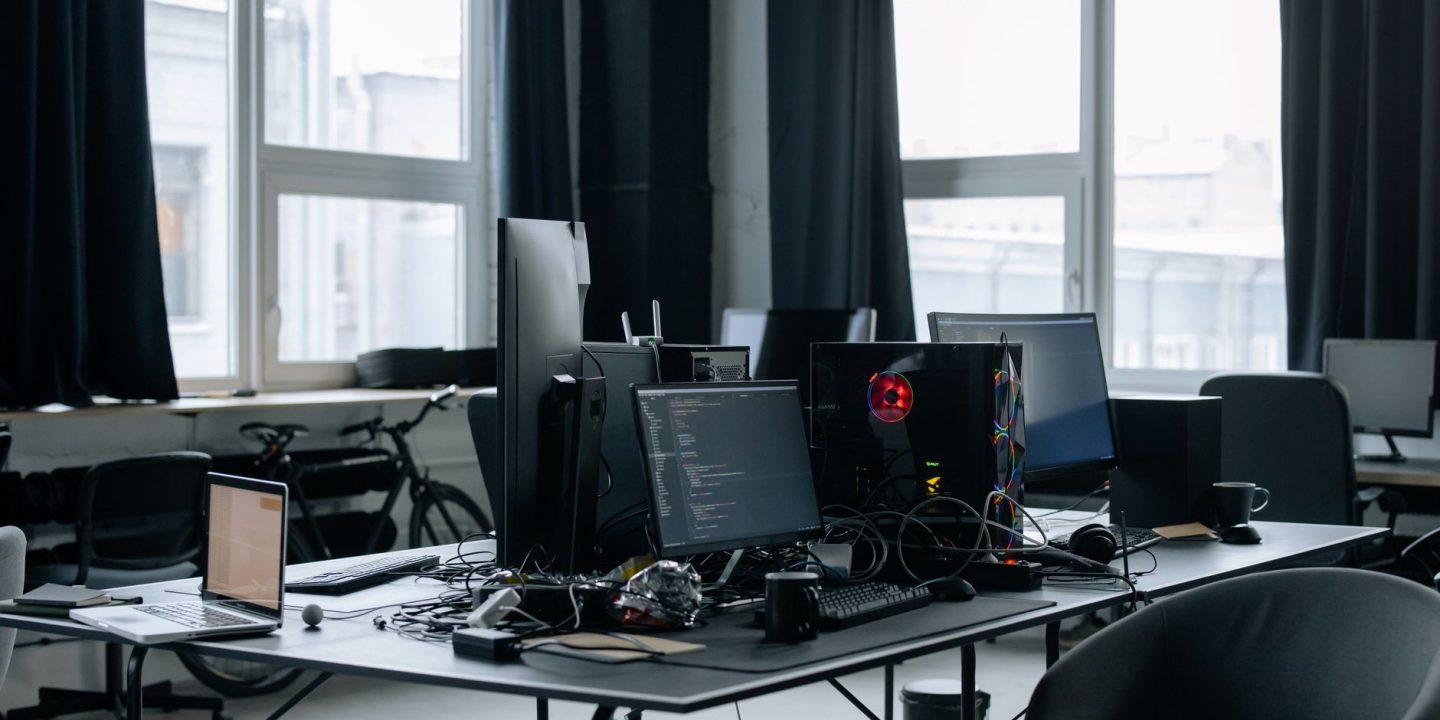 Opuszczone biuro startupu z komputerami i pustymi stanowiskami pracy