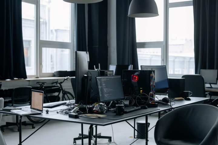 Opuszczone biuro startupu z komputerami i pustymi stanowiskami pracy