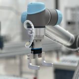 Robotyczna dłoń pracująca przy linii produkcyjnej w fabryce