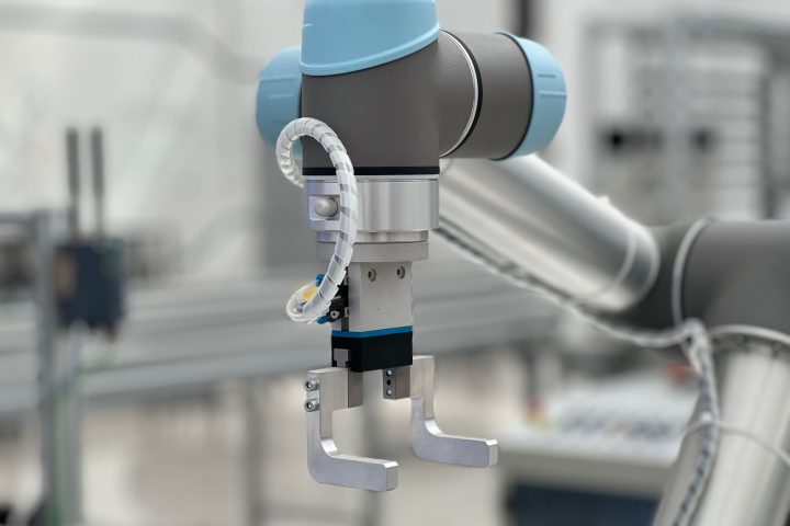 Robotyczna dłoń pracująca przy linii produkcyjnej w fabryce