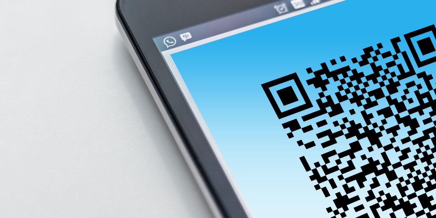 Smartfon skanujący kod QR umieszczony na opakowaniu produktu