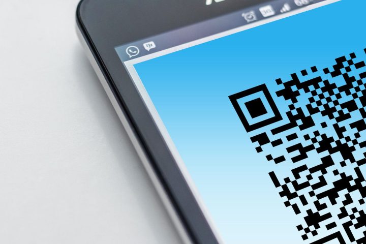 Smartfon skanujący kod QR umieszczony na opakowaniu produktu